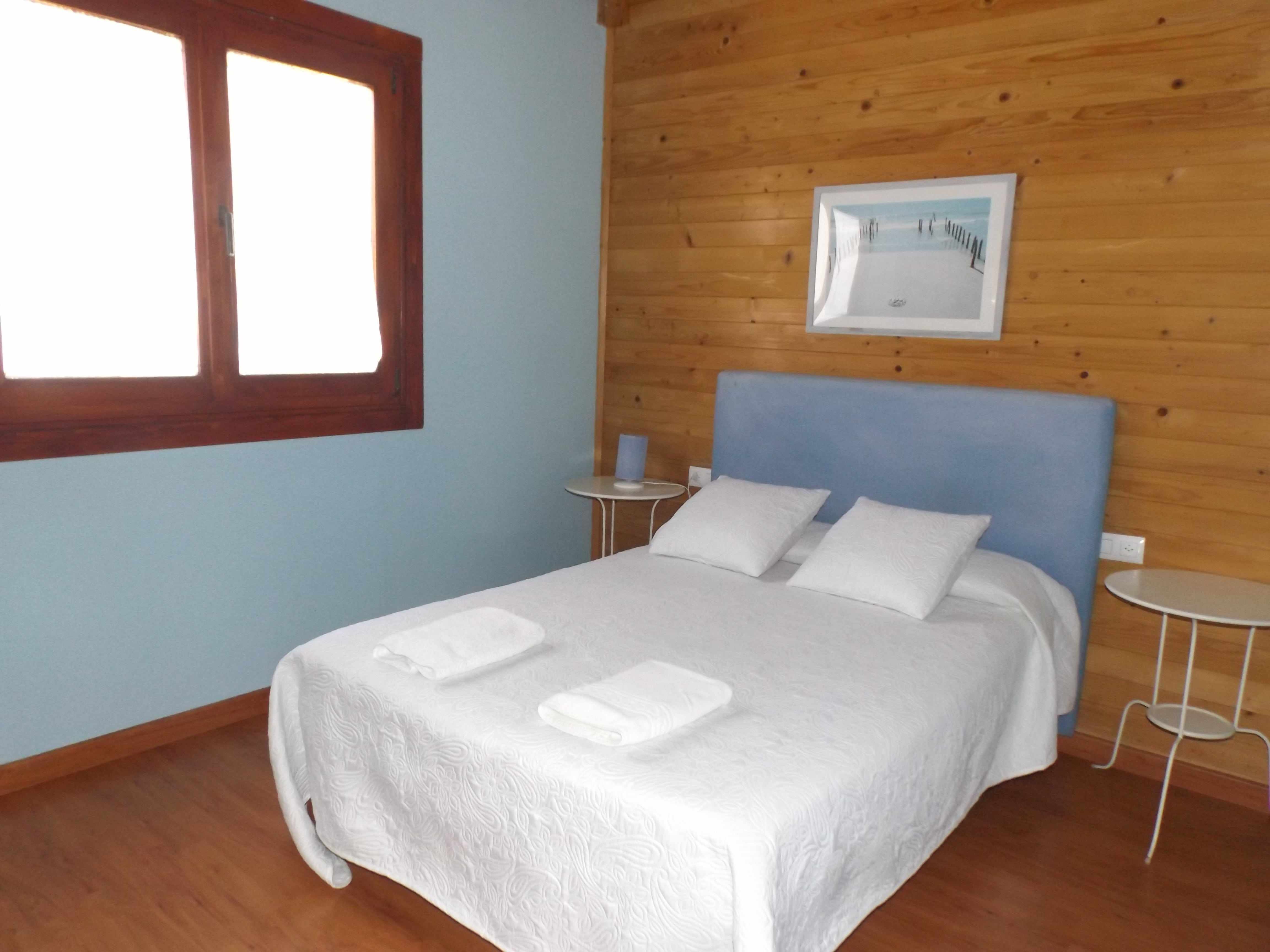Dormitorio con cama doble de la cabaña Santolina, en El Venero de Móstoles